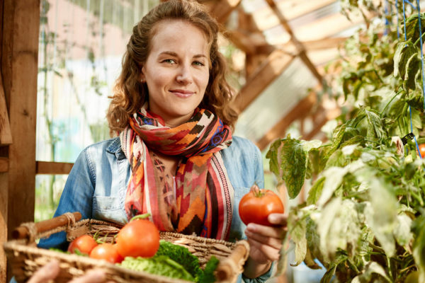 Mädchen riecht an Tomaten