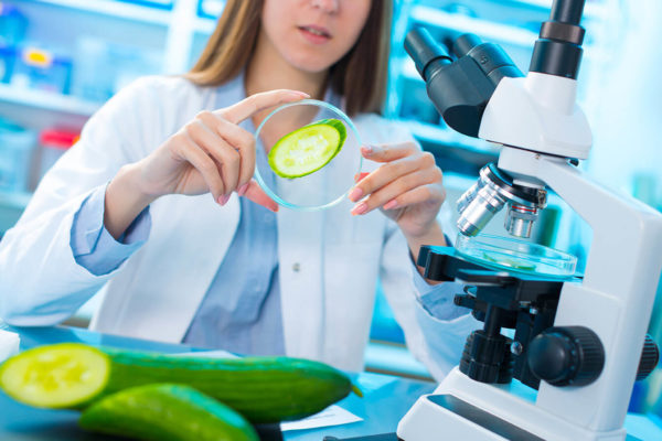 Frau mit Gurke im Labor